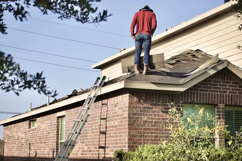 Professional roofer working on a residential roof in Victorian Village